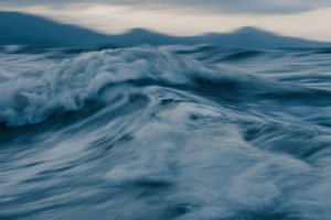 Undo App | Blurry photo of a wave in the ocean, representing the invitation to go deeper in your meditation practice.